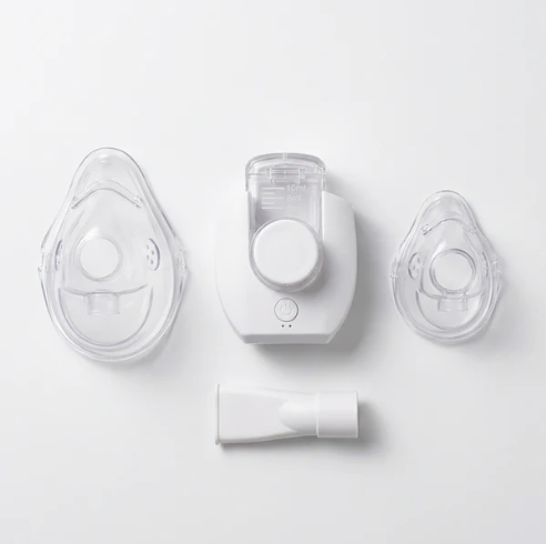 A white and clear handheld nebuliser shown disassembled  ith all the parts.